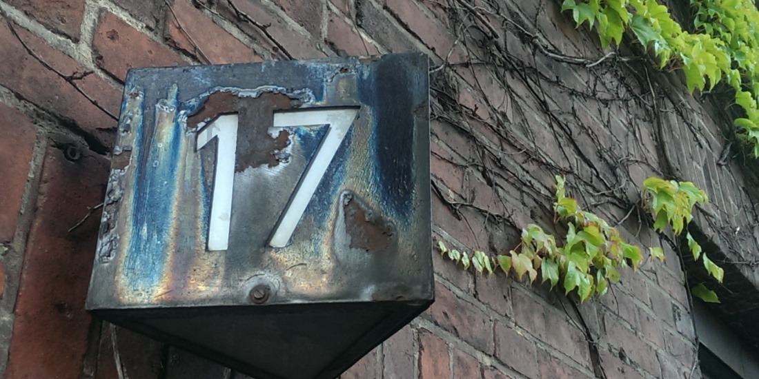 Hausnummernschild mit hinterleuchtbarer Nummer 17, Gehäuse mit vielfarbiger metallischer Patina und Rostflecken überzogen
